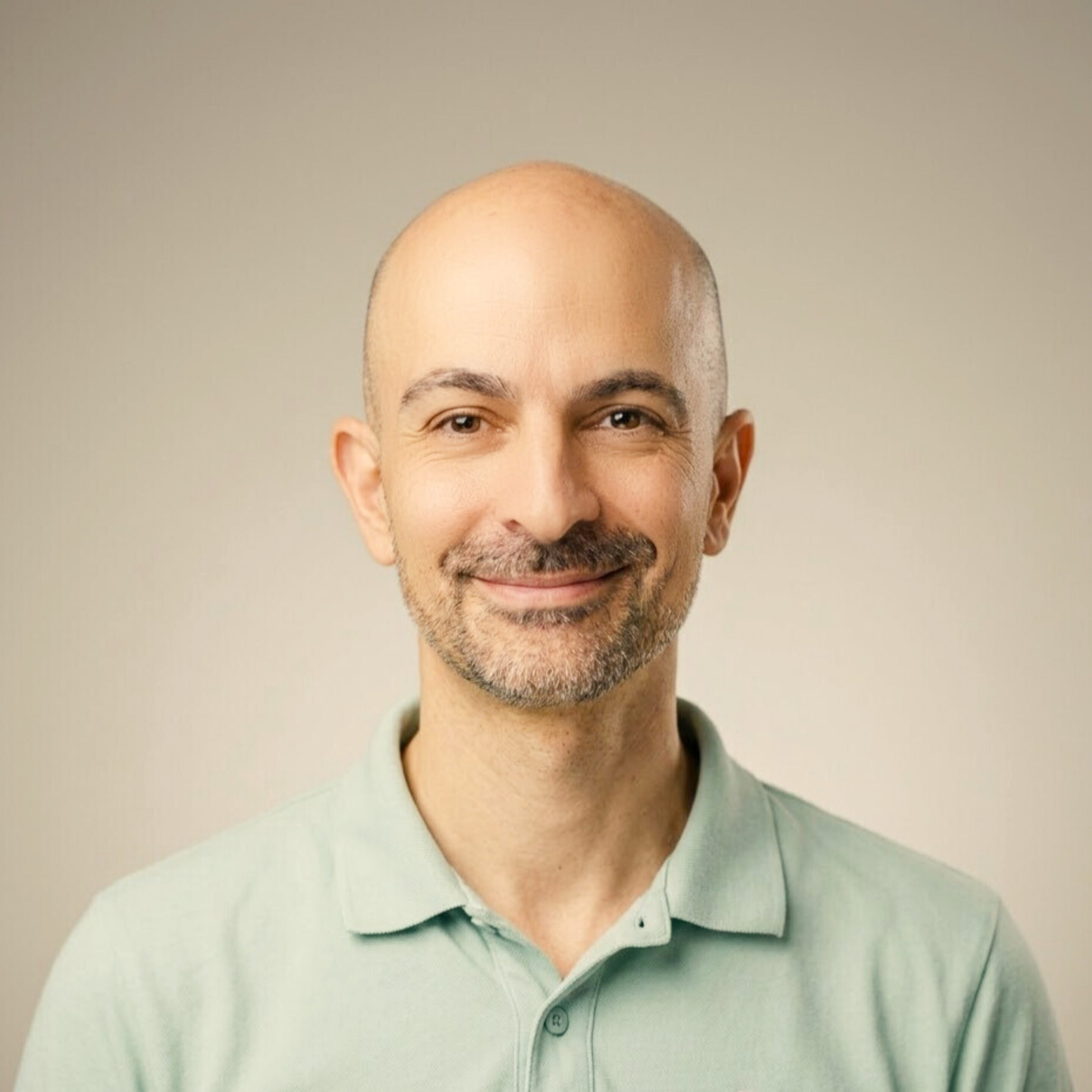 Pediatrician Dr. Nima Memaran laughing with mint green polo shirt.